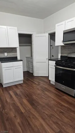a kitchen with granite countertop a stove and a refrigerator