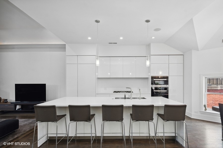 1919 South Prairie Avenue, Unit 5 Chicago, IL 60616 - Photo 9 of 19 a kitchen with a dining table chairs and a refrigerator