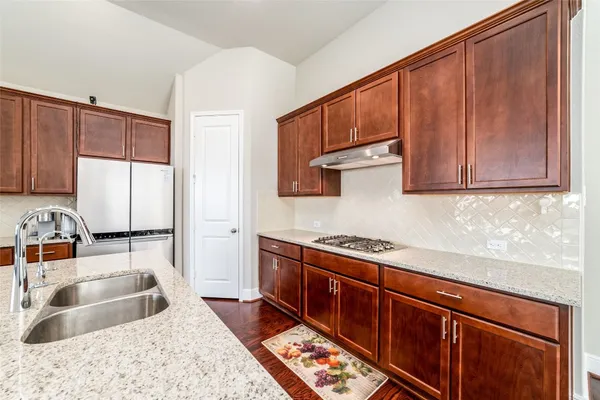 a kitchen with stainless steel appliances granite countertop a sink stove and cabinets