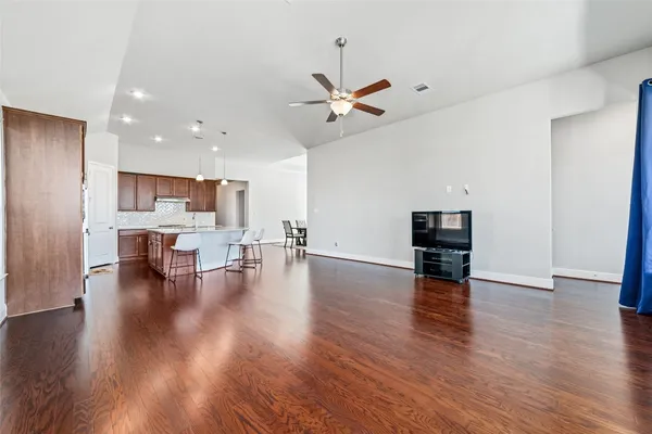 a view of empty room with wooden floor and ceiling fan