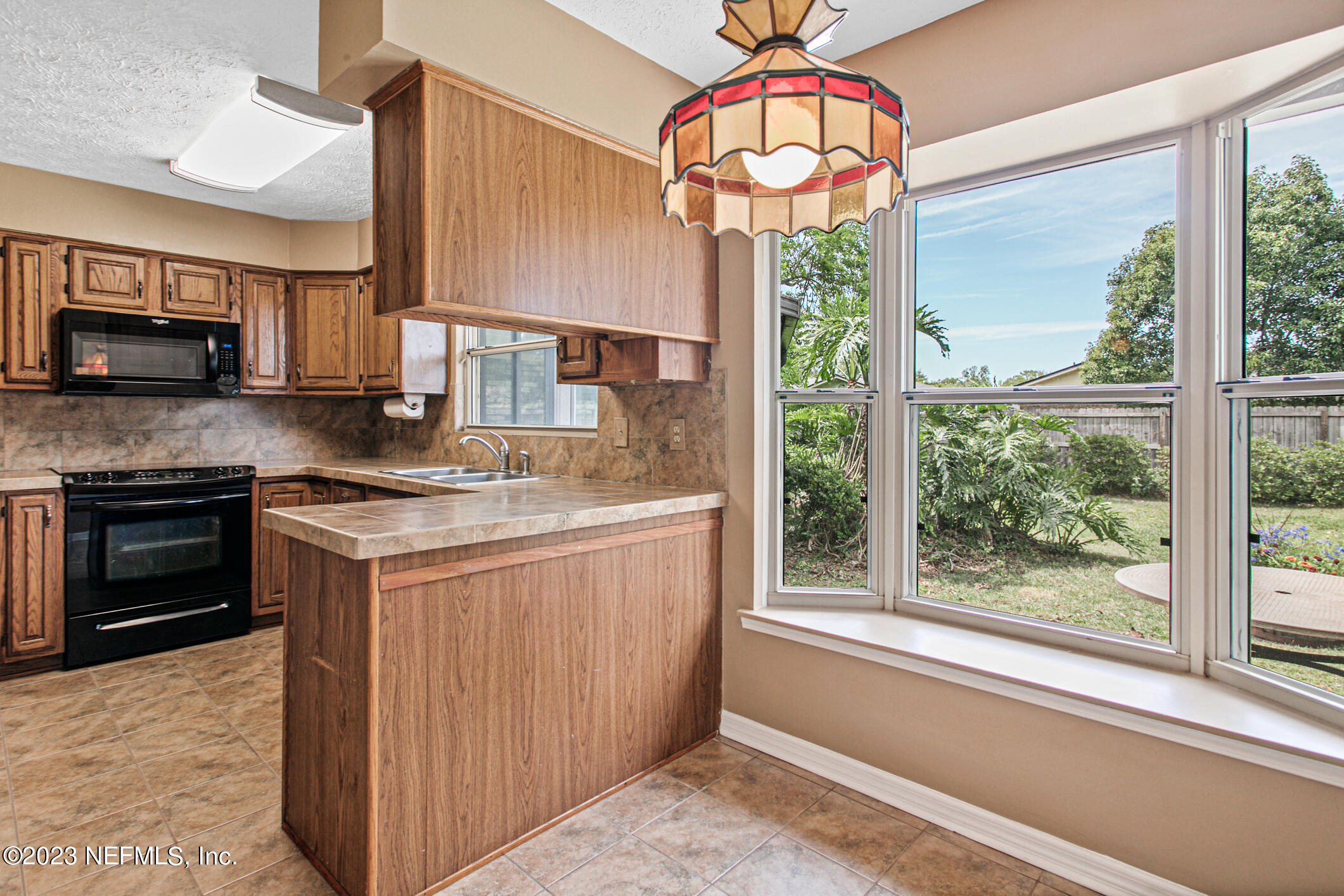 71 Vanderford Road East Orange Park, FL 32073 - Photo 17 of 52 a kitchen with kitchen island granite countertop a stove a sink and a microwave