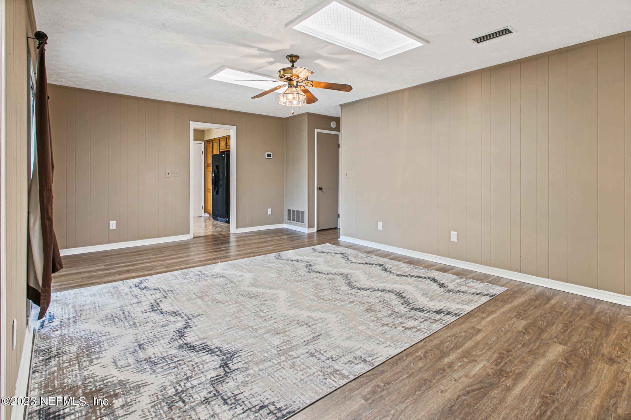 71 Vanderford Road East Orange Park, FL 32073 - Photo 22 of 52 an empty room with a chandelier fan and wooden floor
