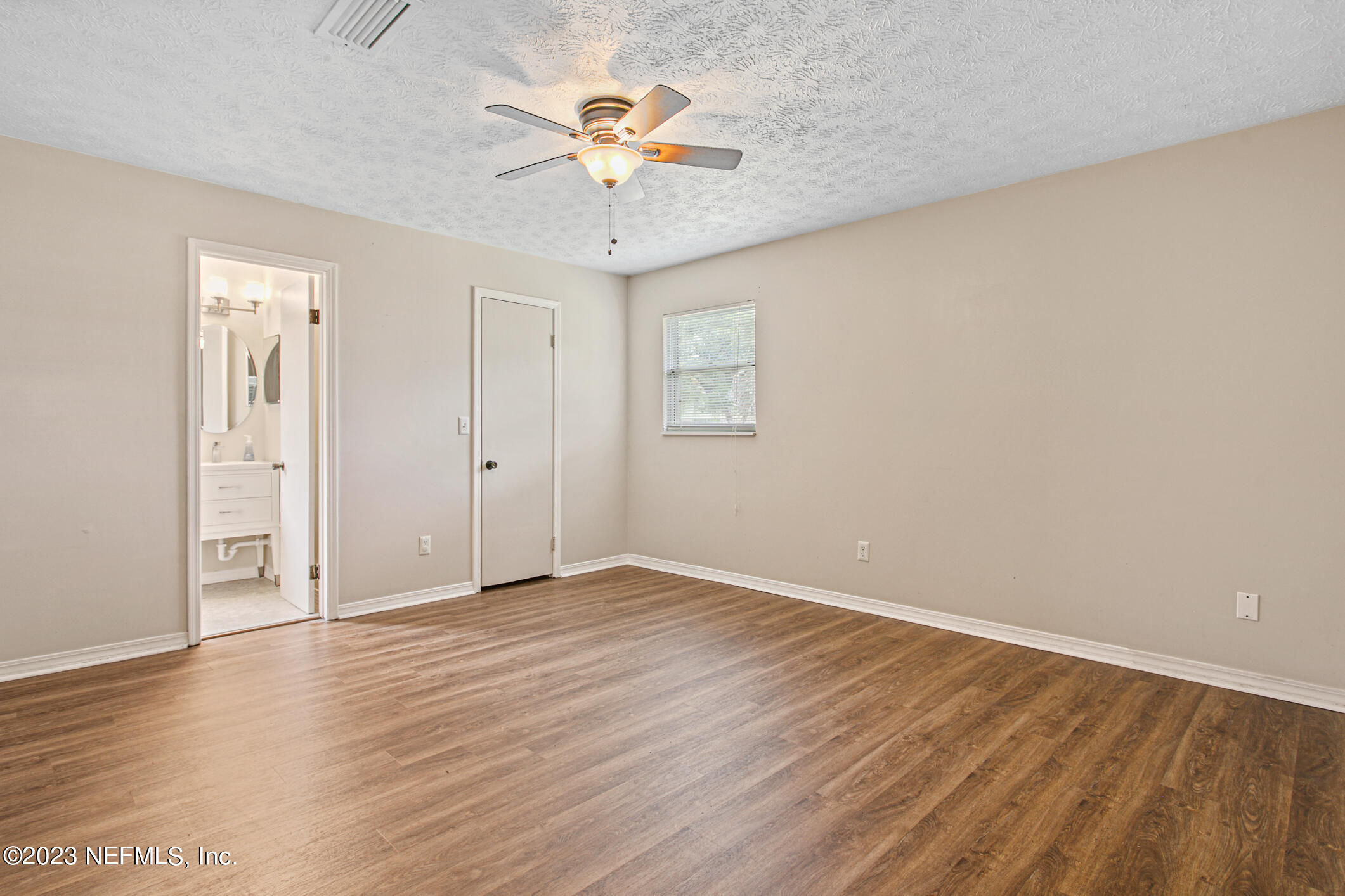 71 Vanderford Road East Orange Park, FL 32073 - Photo 24 of 52 an empty room with wooden floor and chandelier fan