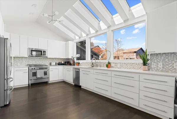 a kitchen with granite countertop white cabinets and white stainless steel appliances