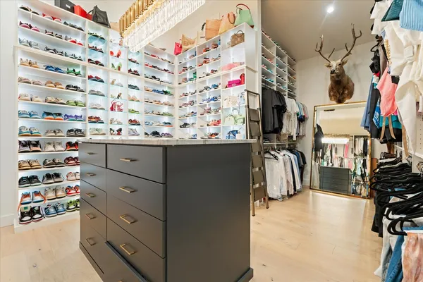 a view of walk in closet with clothes and shoes
