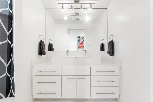a bathroom with a sink vanity and a mirror