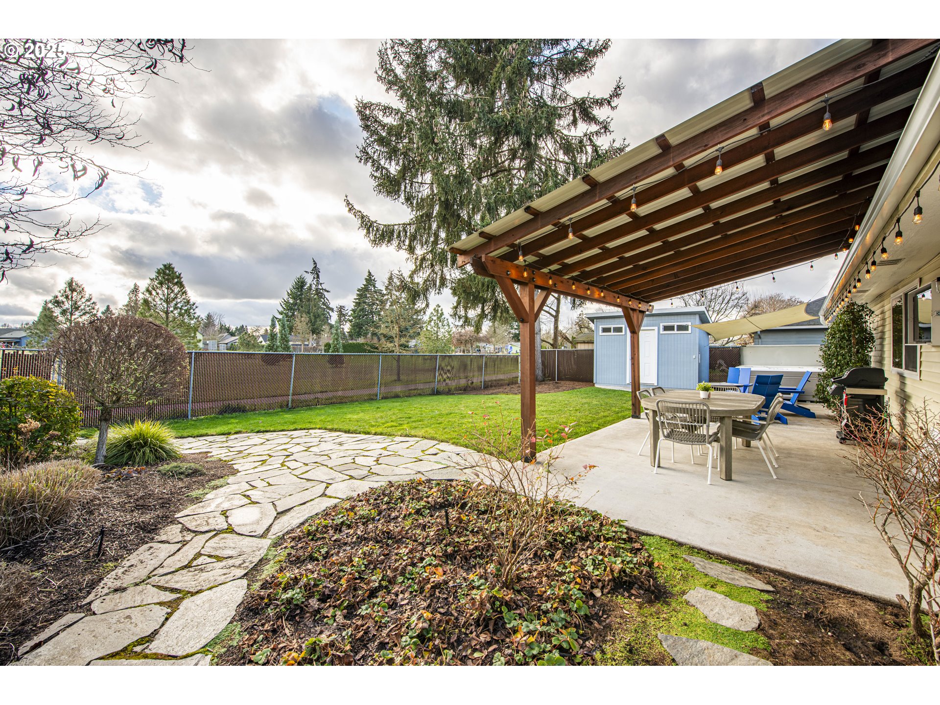 3052 Kentwood Drive Eugene, OR 97401 - Photo 33 of 43 a view of a backyard with table and chairs under an umbrella with large trees