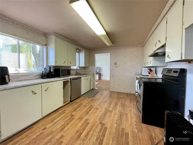 a kitchen with a sink a window and stainless steel appliances