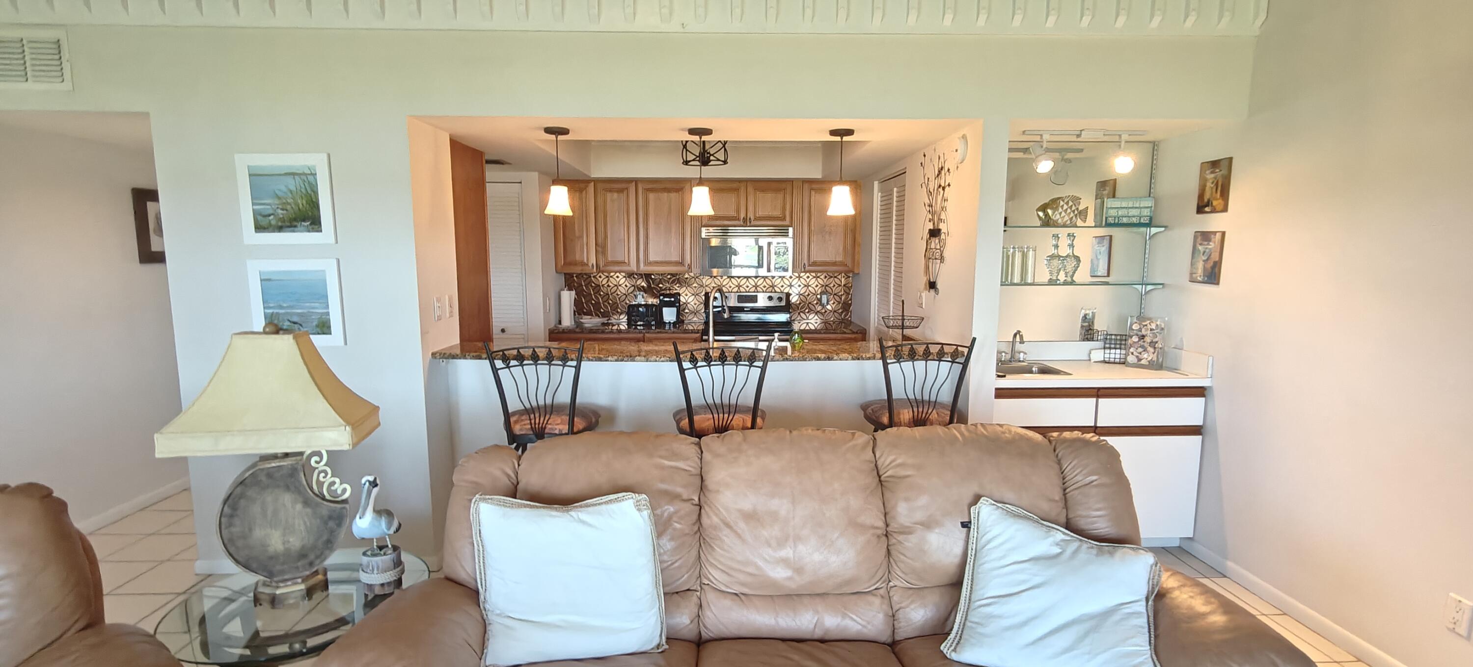 233 Northeast Edgewater Drive, Unit 203 Stuart, FL 34996 - Photo 11 of 30 a living room with furniture a wooden floor and a sink