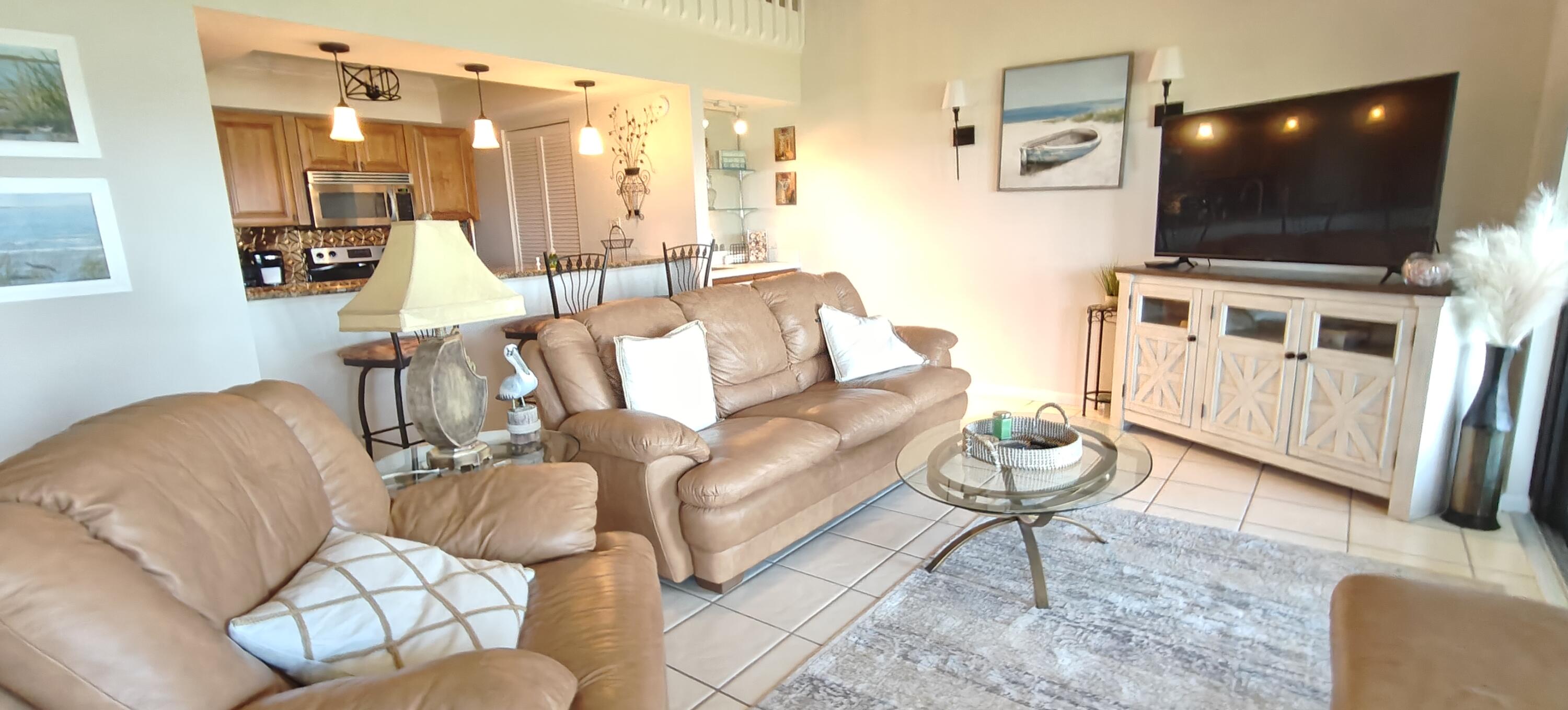 233 Northeast Edgewater Drive, Unit 203 Stuart, FL 34996 - Photo 12 of 30 a living room with furniture and a flat screen tv