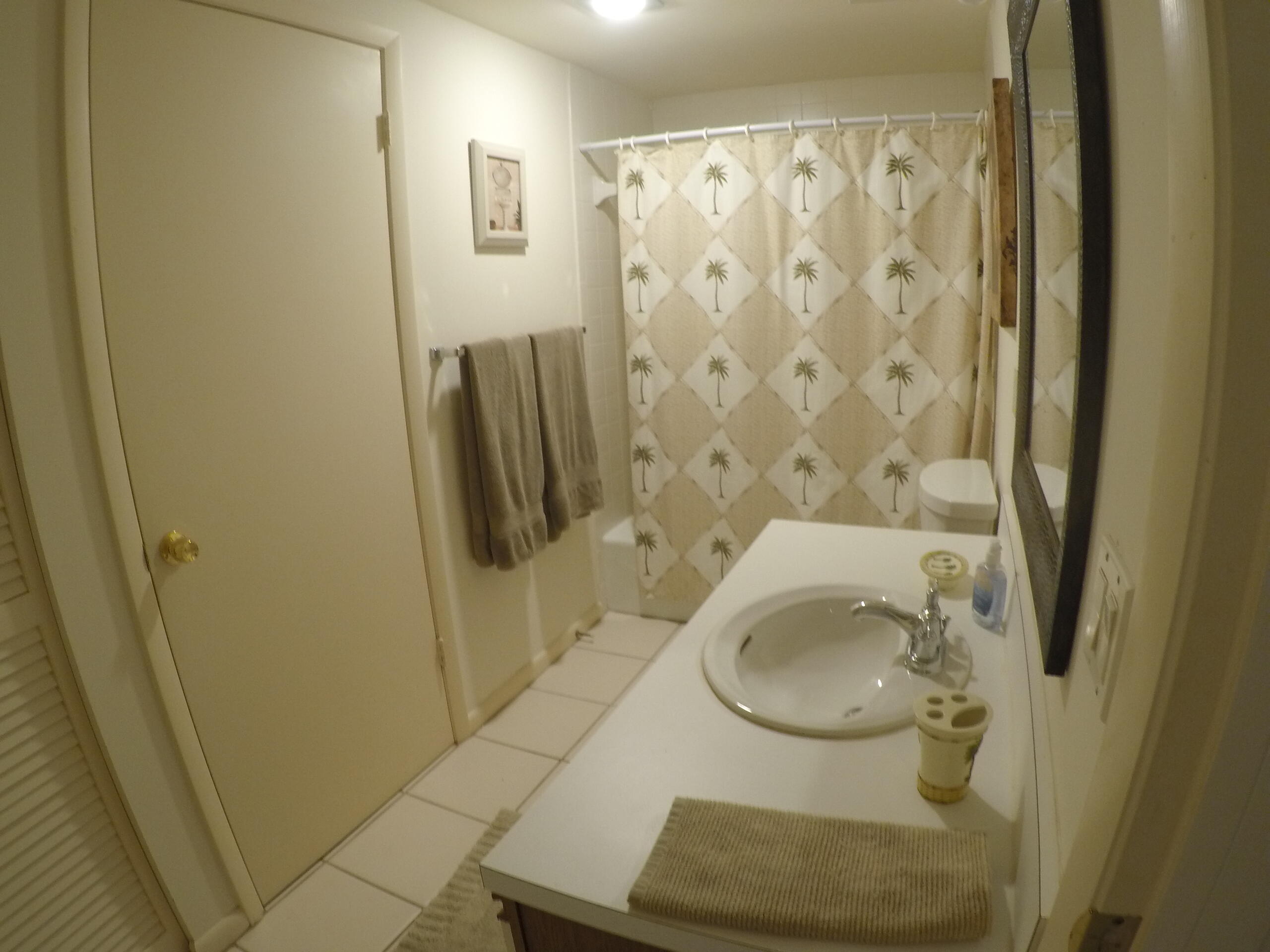 233 Northeast Edgewater Drive, Unit 203 Stuart, FL 34996 - Photo 19 of 30 a bathroom with a sink and mirror