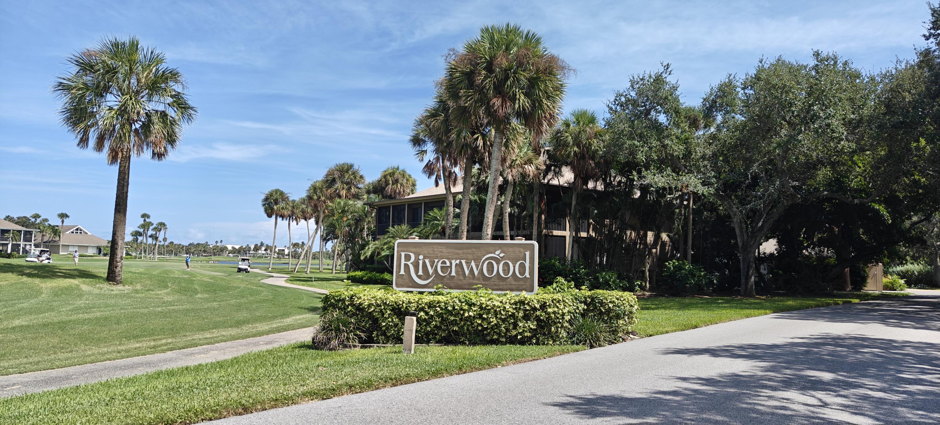 233 Northeast Edgewater Drive, Unit 203 Stuart, FL 34996 - Photo 2 of 30 a sign board with tall trees in the background