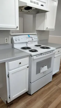 a stove top oven sitting inside of a kitchen