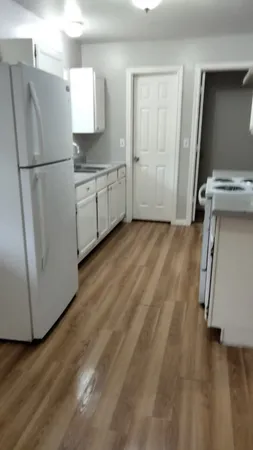 a kitchen with a refrigerator sink and cabinets
