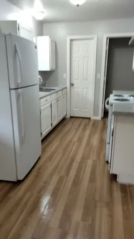 a kitchen with a refrigerator sink and cabinets