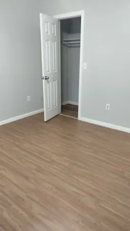 a view of an empty room with wooden floor