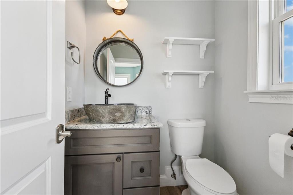 6191 Turtlemound Road New Smyrna Beach, FL 32169 - Photo 66 of 90 a bathroom with a toilet a sink and a mirror