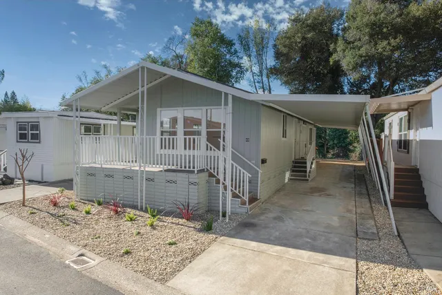 a view of a house with a yard and wooden fence