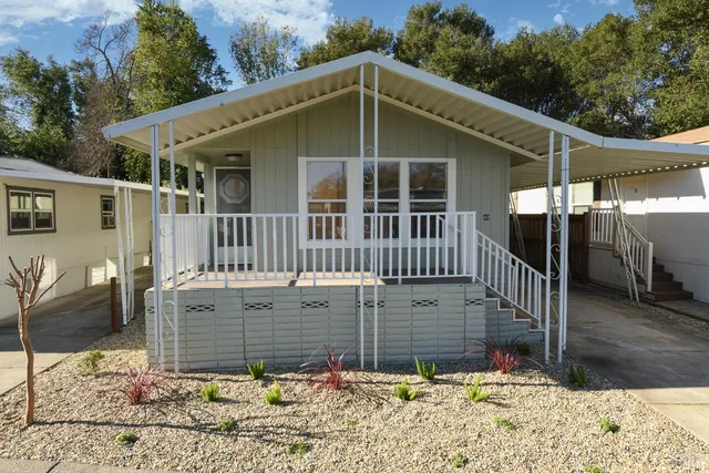 a view of a house with a wooden deck front of house