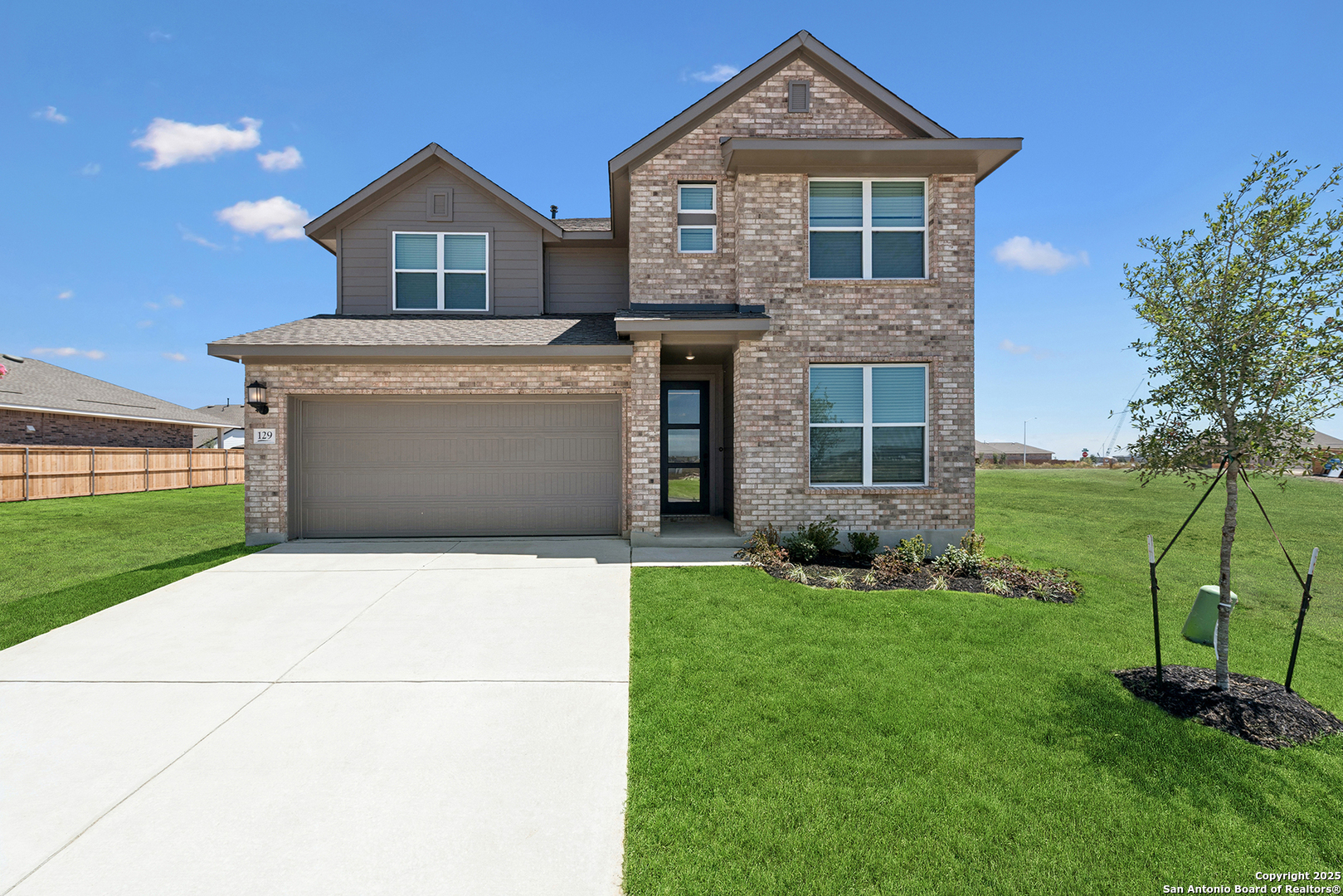 a front view of a house with a yard and trees