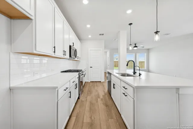 a large kitchen with stainless steel appliances kitchen island granite countertop a sink and cabinets