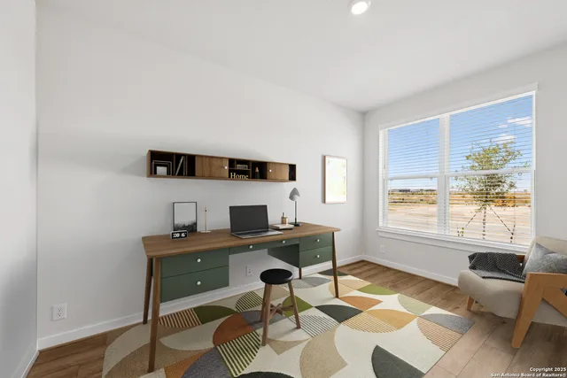 a view of a workspace with furniture and a window