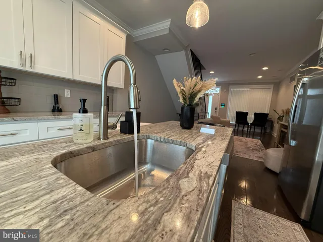 a view of kitchen island with stainless steel appliances granite countertop sink and stove