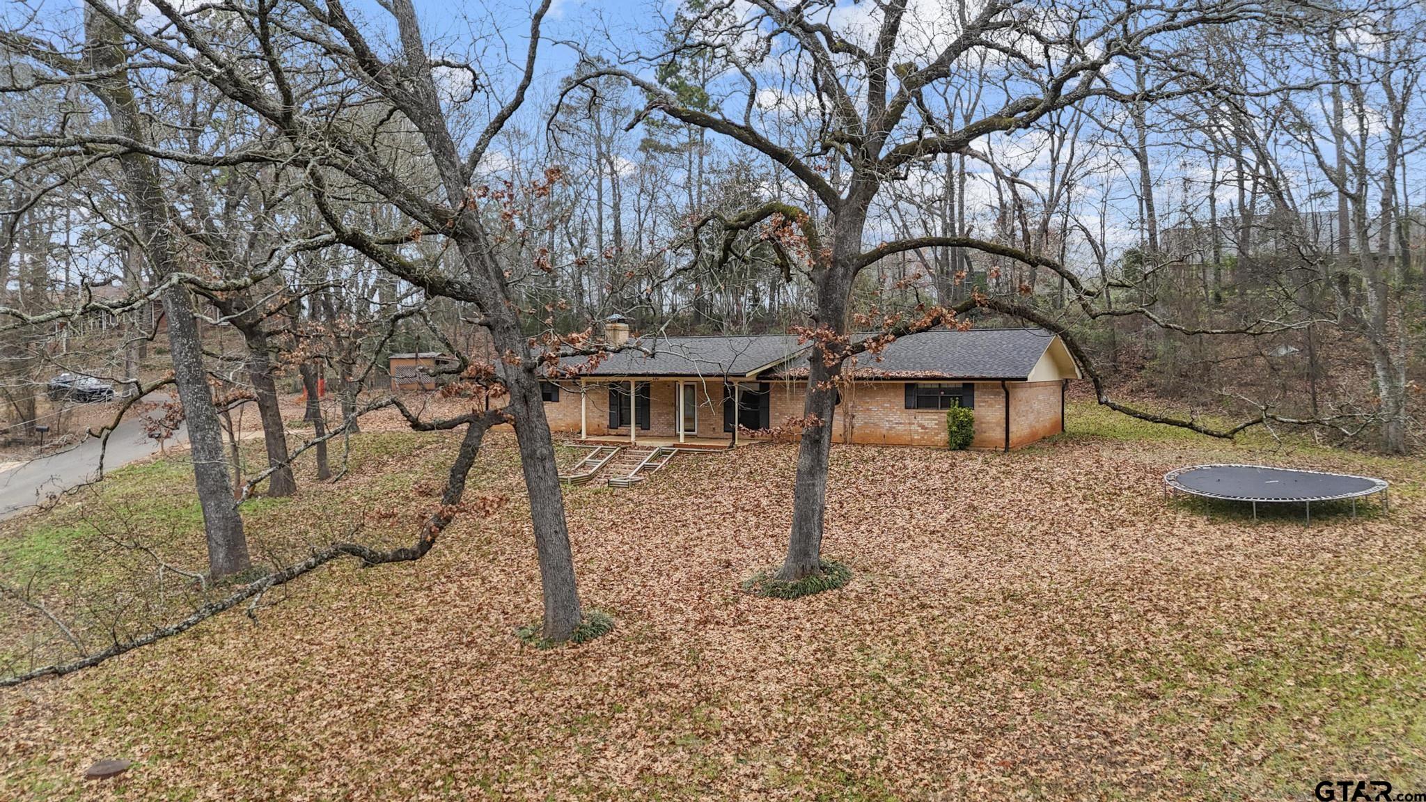 130 Golfcrest Drive Rusk, TX 75785 - Photo 19 of 23 a backyard of a house with table and chairs