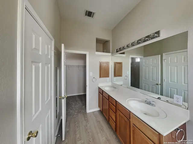 a bathroom with a sink double vanity granite tub and shower