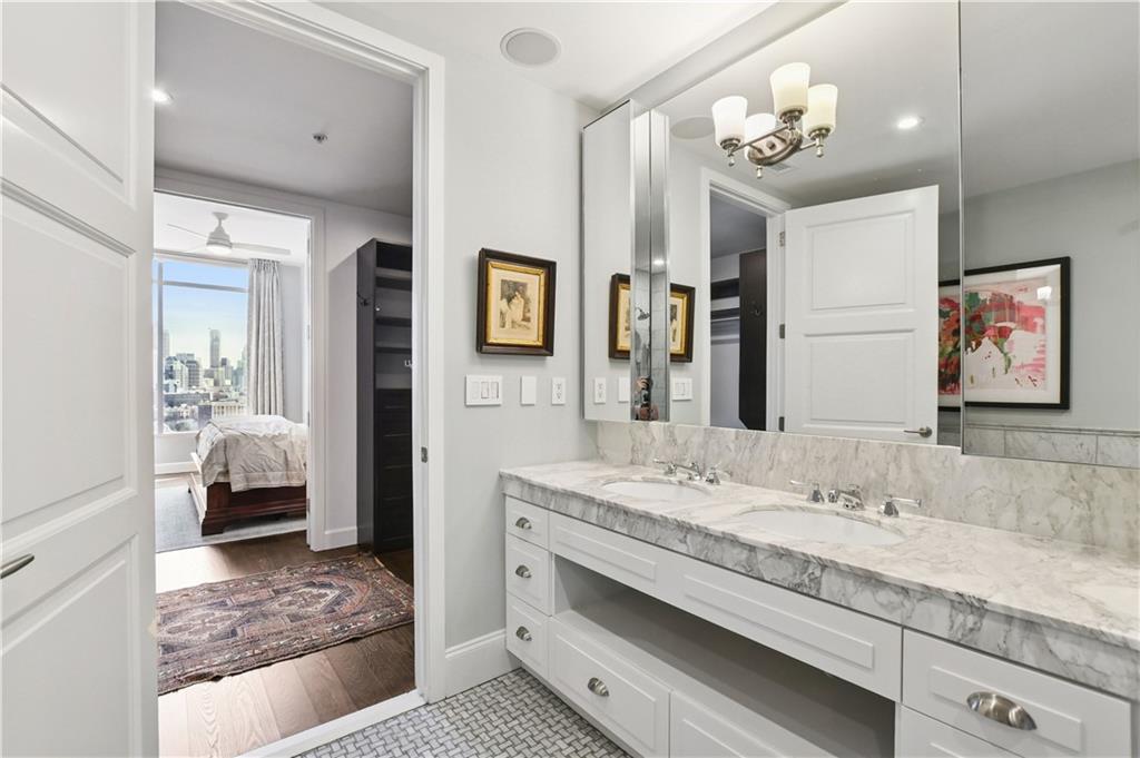 1820 Peachtree Road Northwest, Unit 1510 Atlanta, GA 30309 - Photo 27 of 75 a en suite bathroom with a granite countertop sink and a mirror