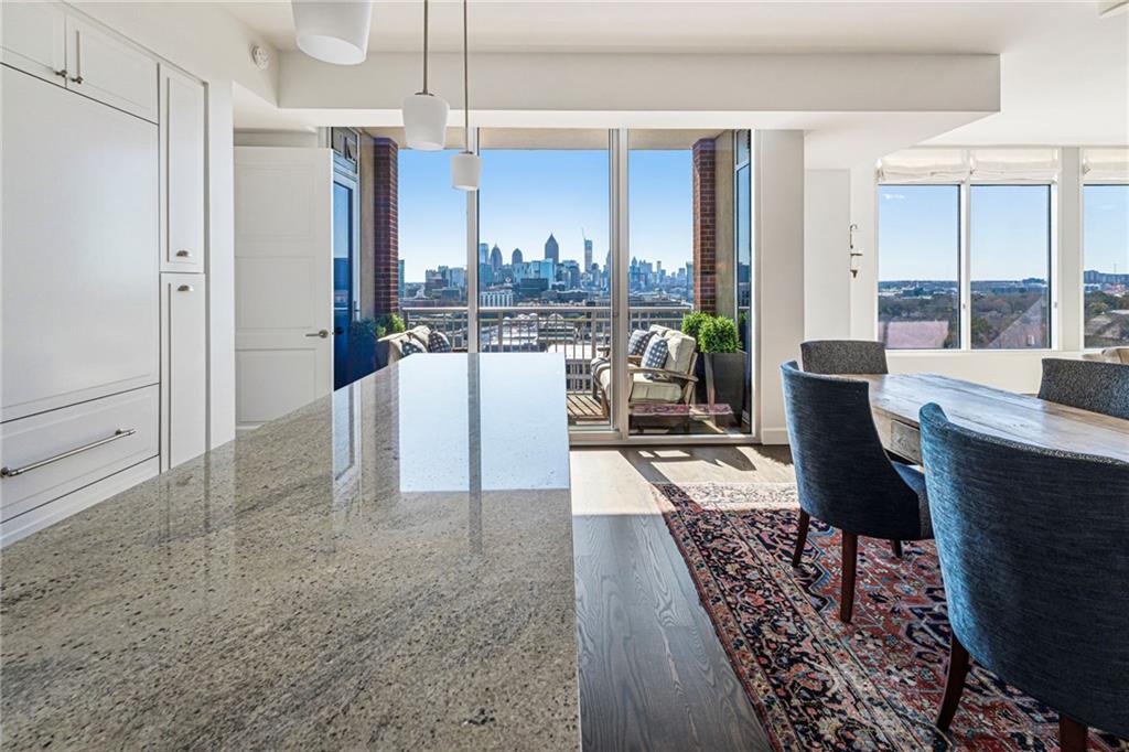 1820 Peachtree Road Northwest, Unit 1510 Atlanta, GA 30309 - Photo 5 of 75 a living room with furniture a chandelier and a dining table with wooden floor