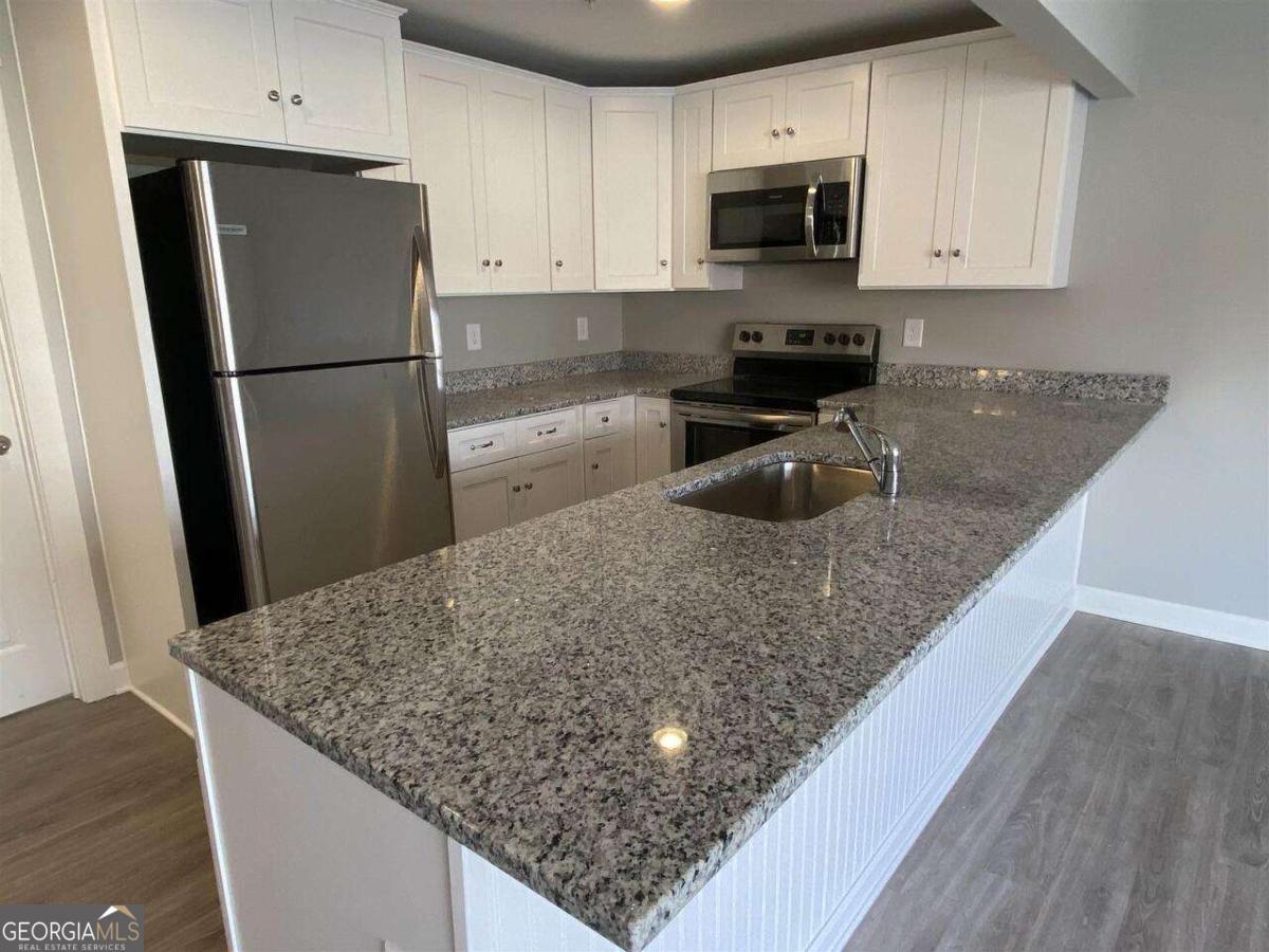 95 North Jackson Street, Unit 4 Hartwell, GA 30643 - Photo 3 of 8 a kitchen with granite countertop a refrigerator and a sink
