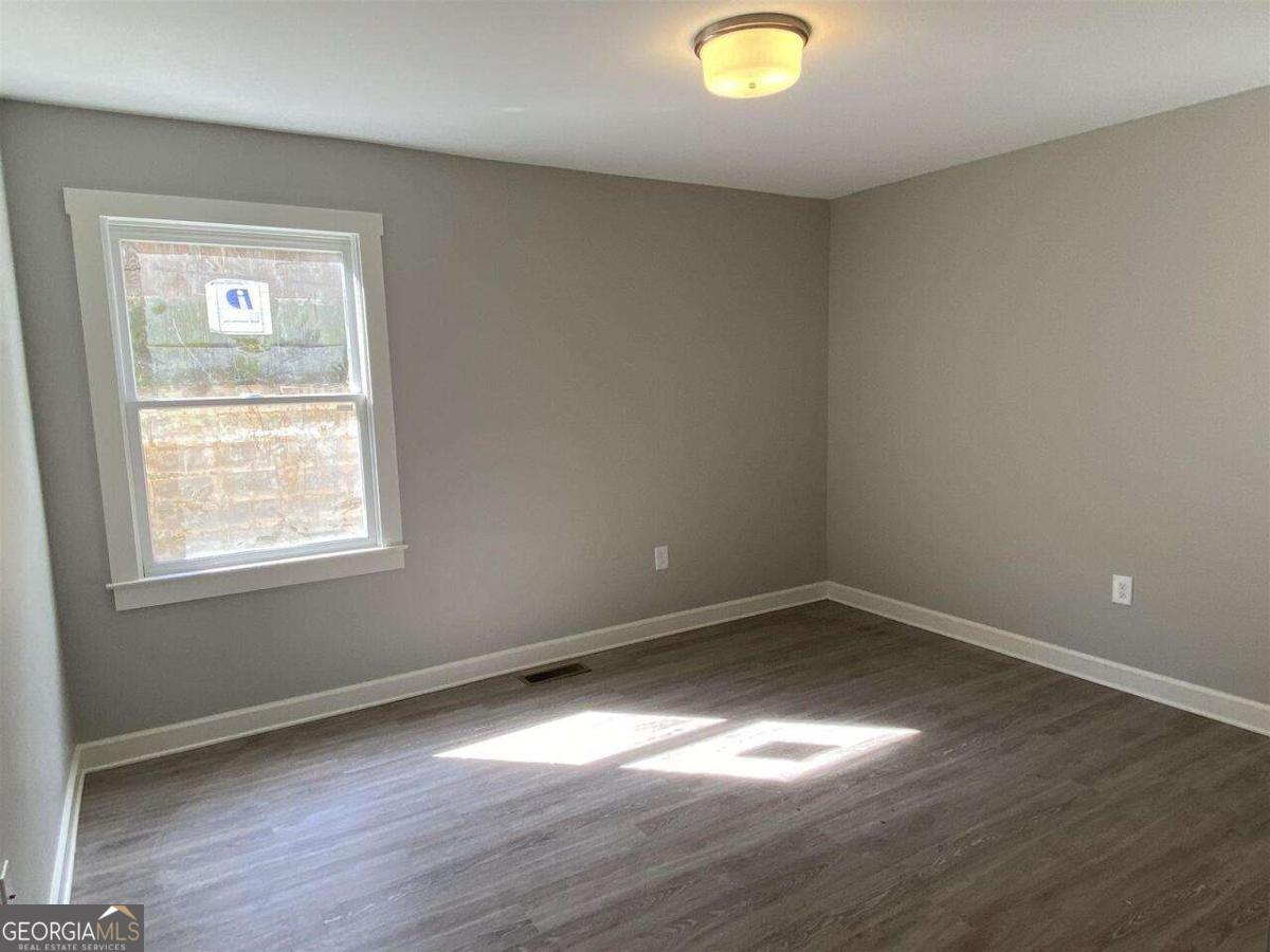 95 North Jackson Street, Unit 4 Hartwell, GA 30643 - Photo 4 of 8 an empty room with wooden floor and windows