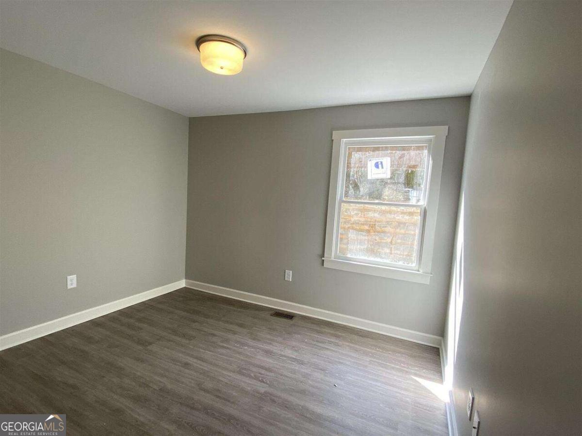 95 North Jackson Street, Unit 4 Hartwell, GA 30643 - Photo 5 of 8 wooden floor in an empty room with a window