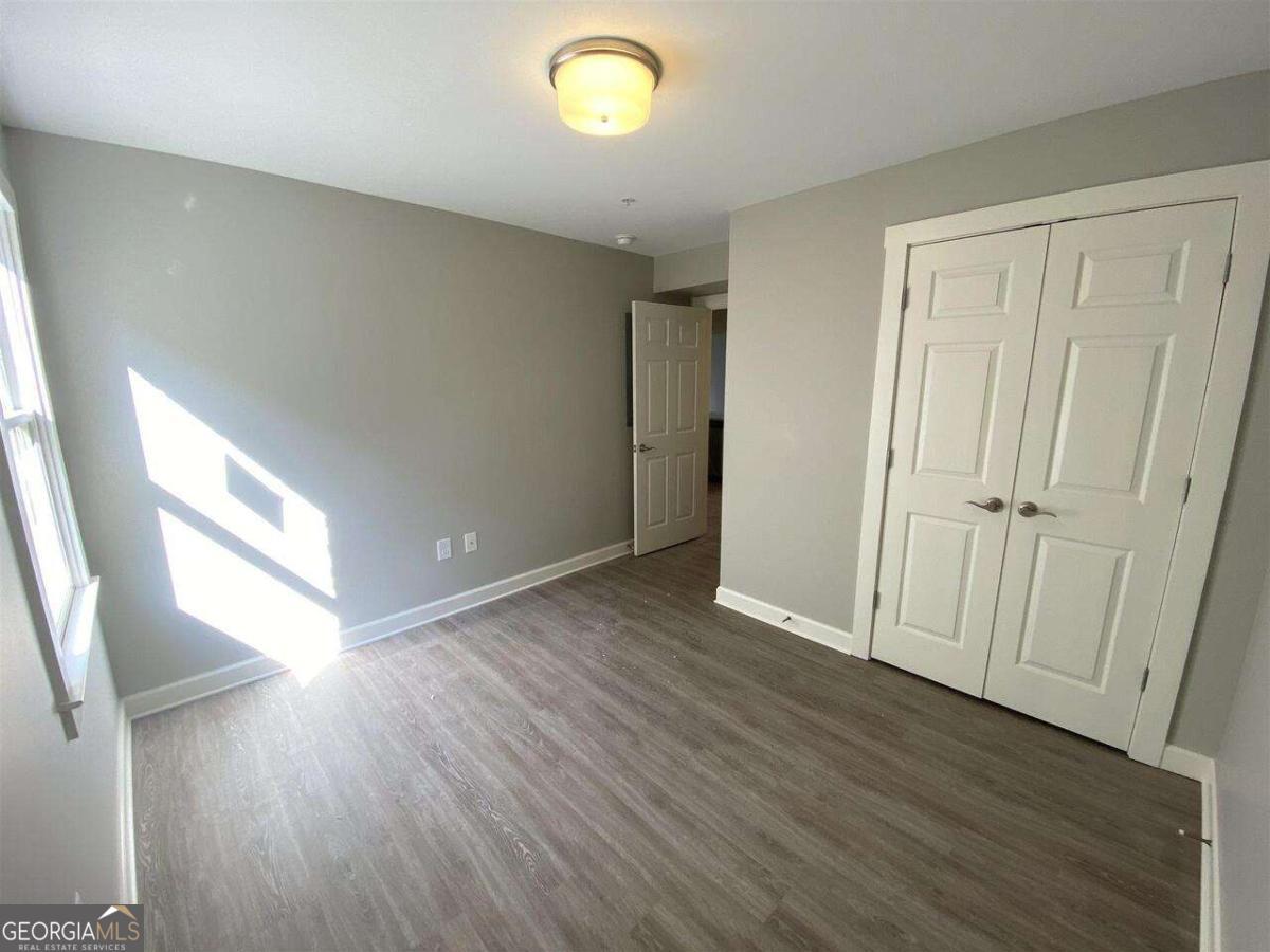 95 North Jackson Street, Unit 4 Hartwell, GA 30643 - Photo 6 of 8 an empty room with wooden floor and windows