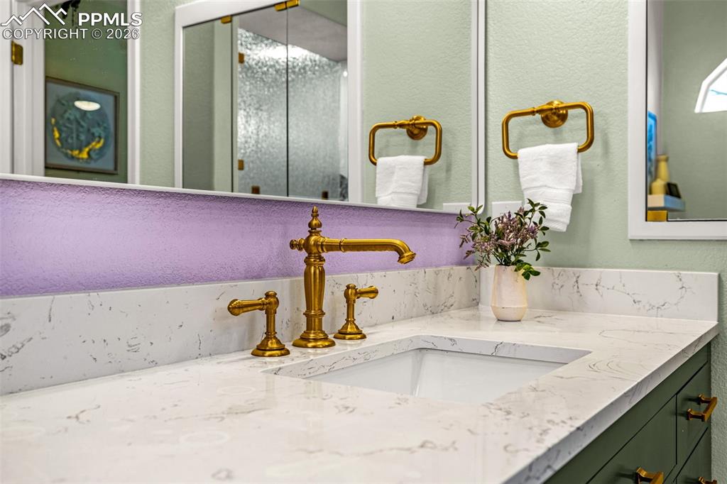 1310 Bison Ridge Drive Colorado Springs, CO 80919 - Photo 19 of 45 a bathroom with a granite countertop sink and a mirror