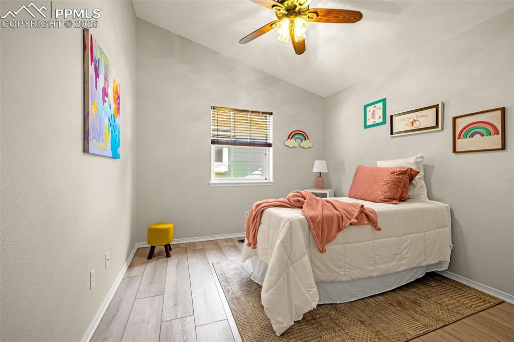 1310 Bison Ridge Drive Colorado Springs, CO 80919 - Photo 22 of 45 a bedroom with a bed and a chandelier