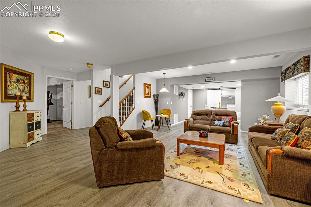 1310 Bison Ridge Drive Colorado Springs, CO 80919 - Photo 28 of 45 a living room with furniture and a wooden floor