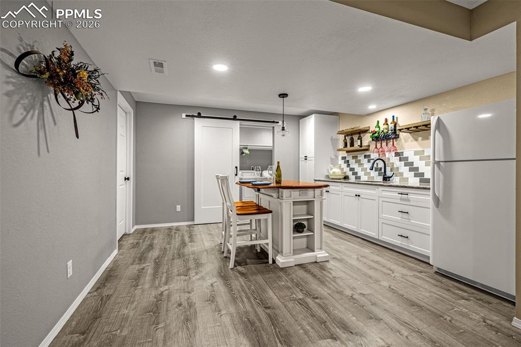 1310 Bison Ridge Drive Colorado Springs, CO 80919 - Photo 31 of 45 a kitchen with white cabinets and stainless steel appliances