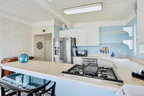 a kitchen with stainless steel appliances a table and chairs in it