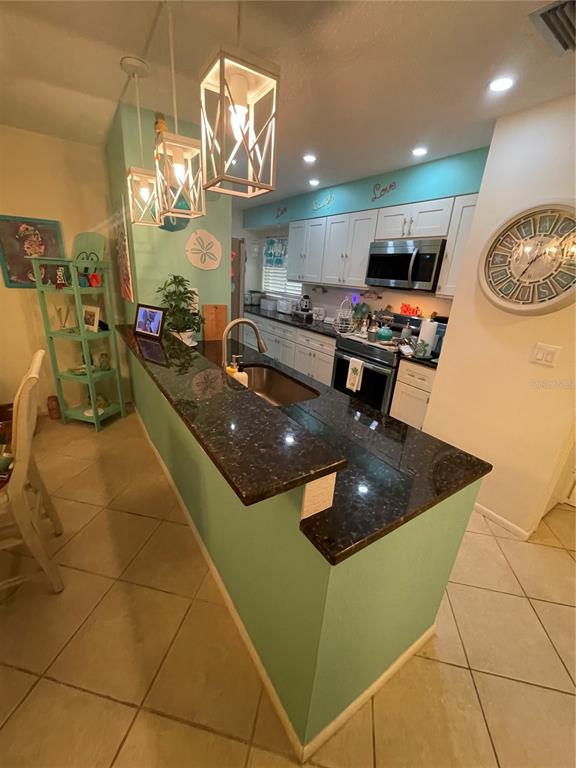 127 Cypress Pond Road Port Orange, FL 32128 - Photo 37 of 68 a kitchen with stainless steel appliances granite countertop a sink a stove top oven a counter space and cabinets