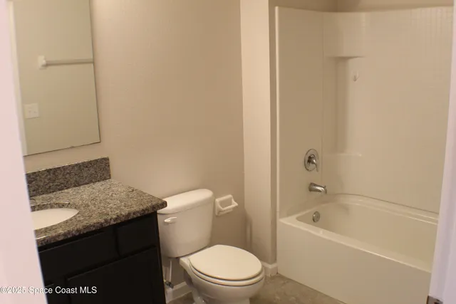 a bathroom with a granite countertop toilet a sink and bathtub
