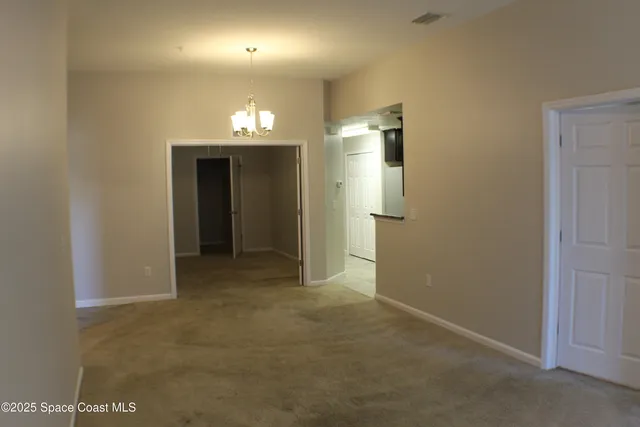 an empty room with an entryway and hallway