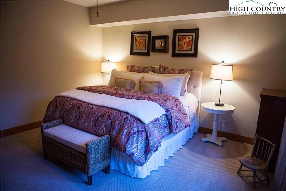 138 South Camp Road, Unit 104 Boone, NC 28607 - Photo 23 of 33 a bedroom with a bed a lamp and a window
