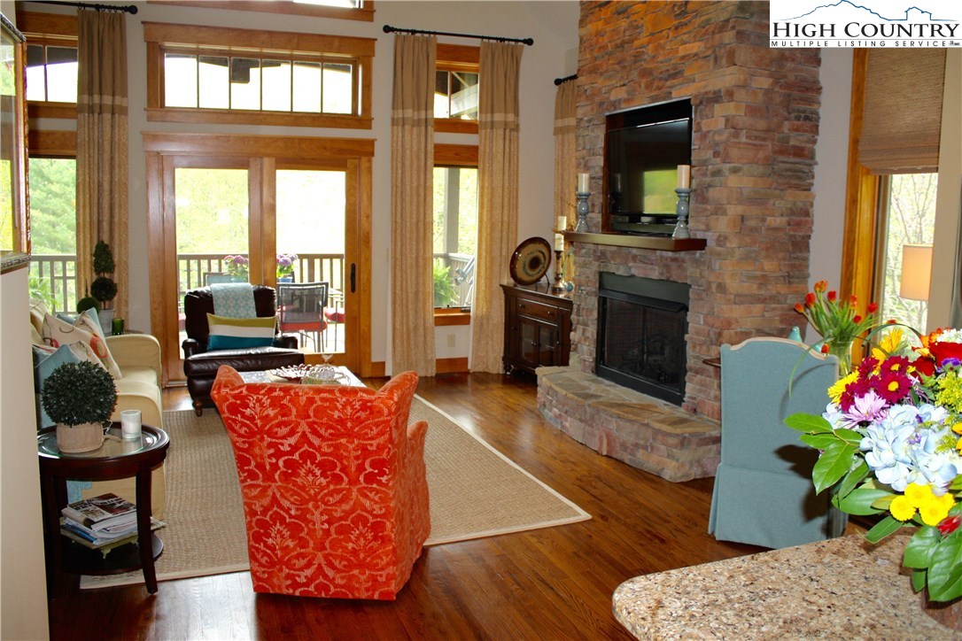 138 South Camp Road, Unit 104 Boone, NC 28607 - Photo 8 of 33 a living room with furniture a flat screen tv and a floor to ceiling window