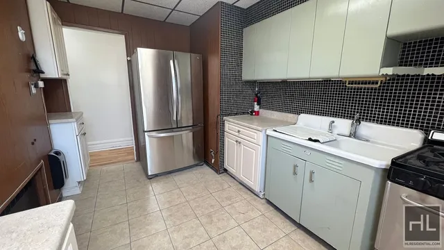 a kitchen with a sink a refrigerator and cabinets