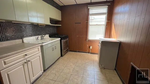 a kitchen with a sink a stove and cabinets