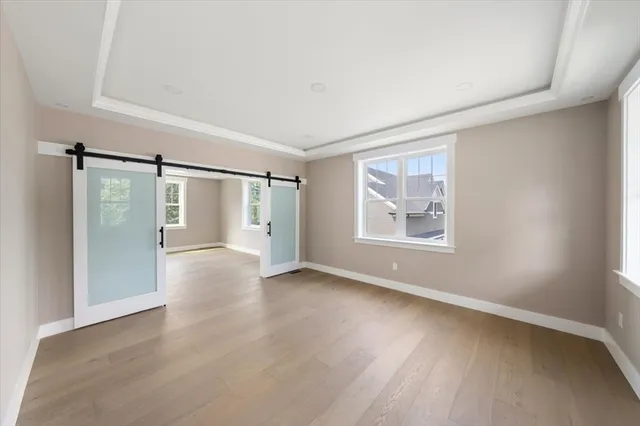 a view of an empty room with a window and wooden floor