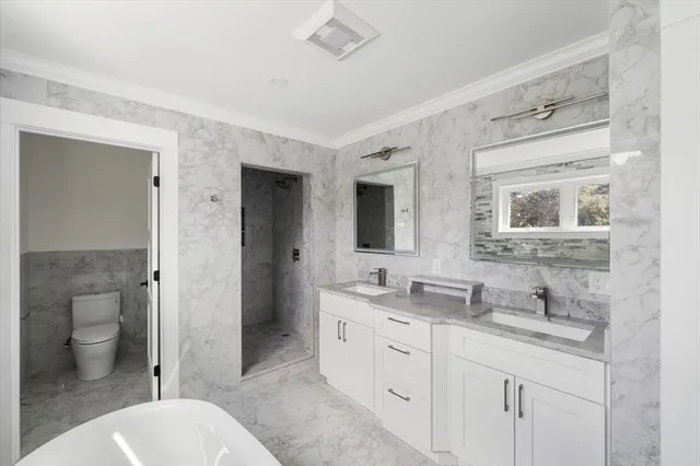 a bathroom with a granite countertop double vanity sink a mirror and a toilet