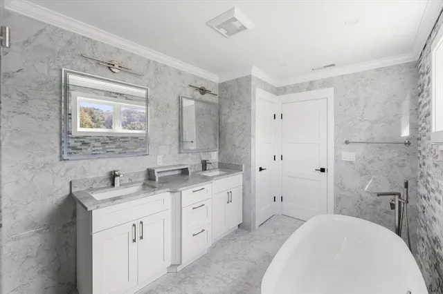 a bathroom with a double vanity sink mirror and bathtub